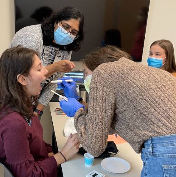 Student practicing oral mechanism testing on a team member as part of clinical bedside swallow examination
